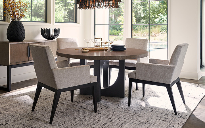 The Regent round dining table offers a bold contemporary statement with its juxtaposed U-shaped bases in the Tunis finish. The top features a radial matched pattern of quartered white oak and a thick apron, giving the design a substantial presence in the 